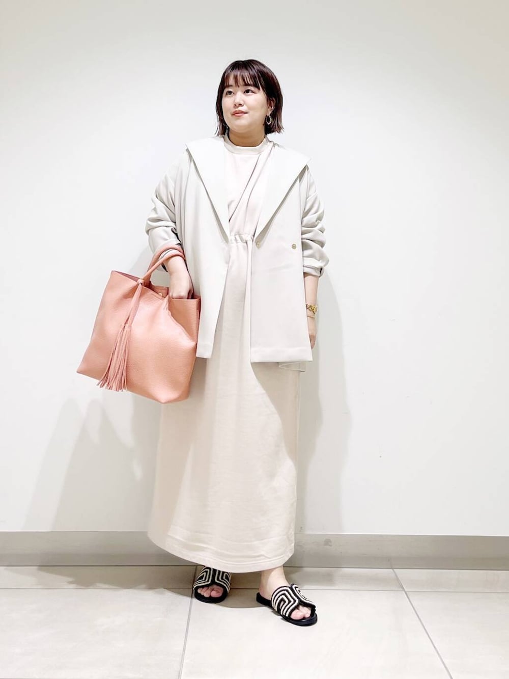 ピンク系のトートバッグ、ベージュ系のその他アウター、ベージュ系のワンピースを着用したレディースの春コーディネートの9枚目の写真