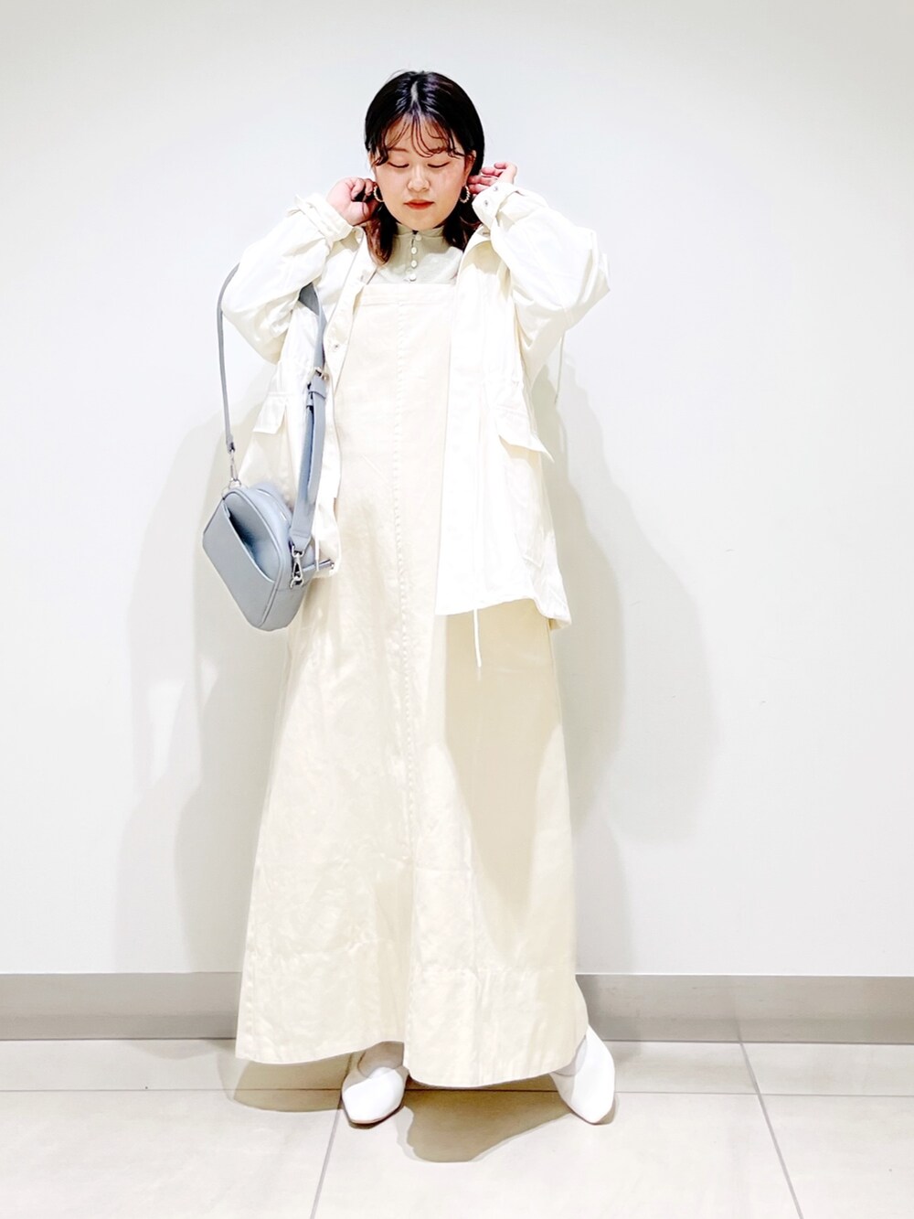 ベージュ系のワンピース、ホワイト系のブルゾン、グリーン系のTシャツ/カットソーを着用したレディースの春コーディネートの2枚目の写真