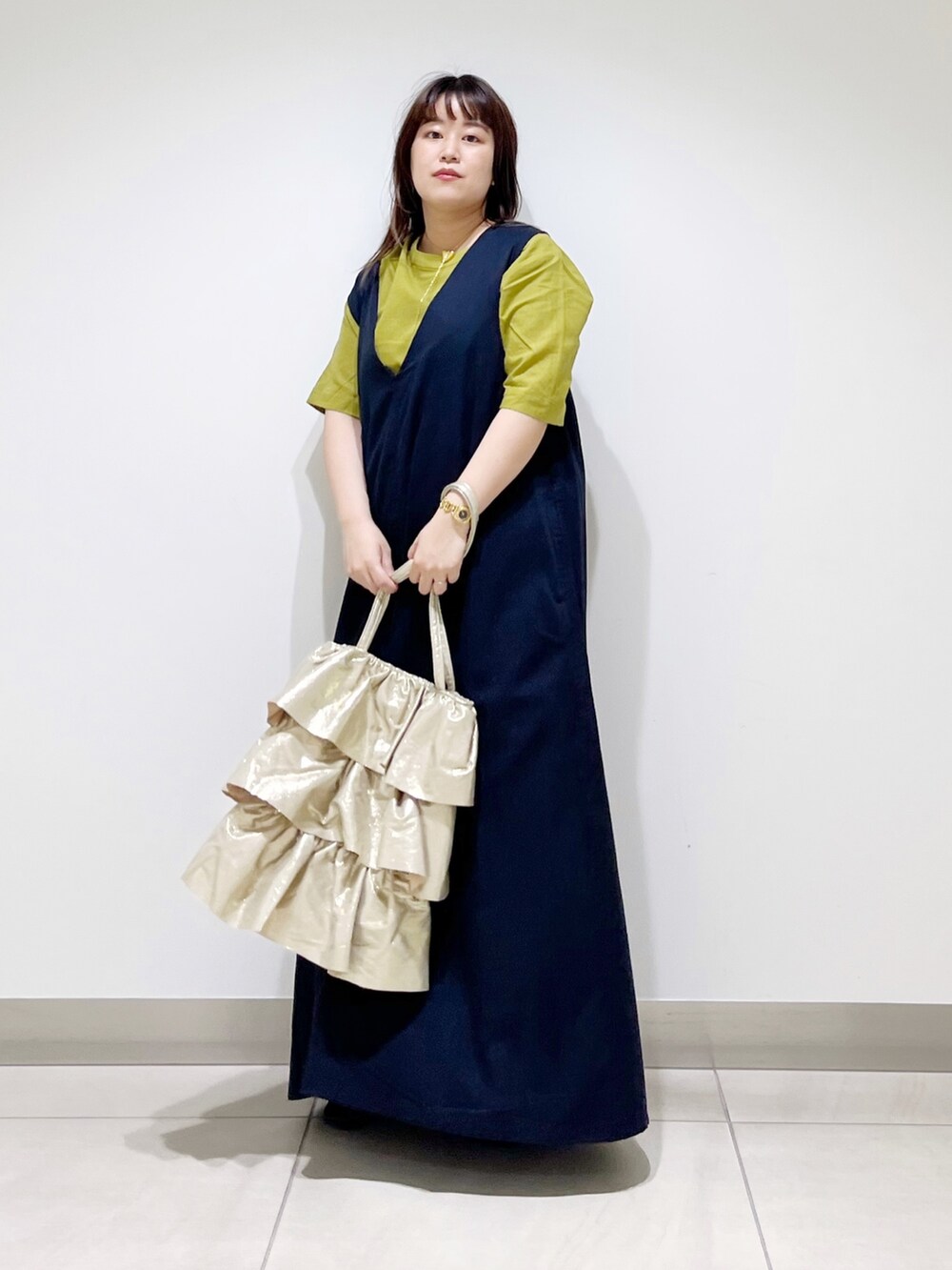 イエロー系のシャツ/ブラウス、ブルー系のワンピース、ゴールド系のトートバッグを着用したレディースの夏コーディネートの3枚目の写真