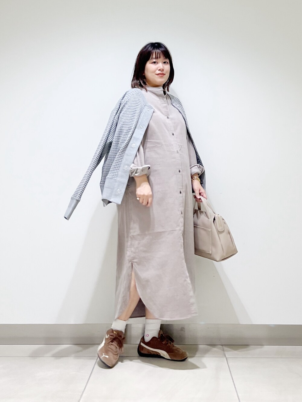 ベージュ系のワンピース、グレー系のカーディガン/ボレロ、グレー系のボストンバッグを着用したレディースの秋コーディネートの7枚目の写真