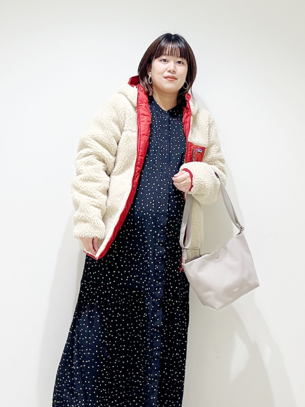 レッド系のその他アウター、ブラック系のワンピース、グレー系のショルダーバッグを着用したレディースの秋コーディネートの3枚目の写真