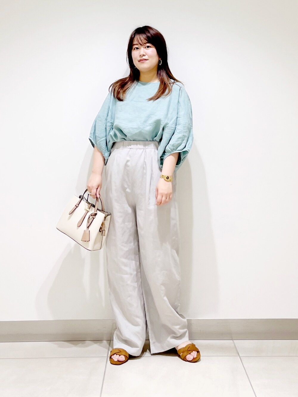 グリーン系のシャツ/ブラウス、ベージュ系のその他パンツ、ホワイト系のトートバッグを着用したレディースの夏コーディネートの2枚目の写真