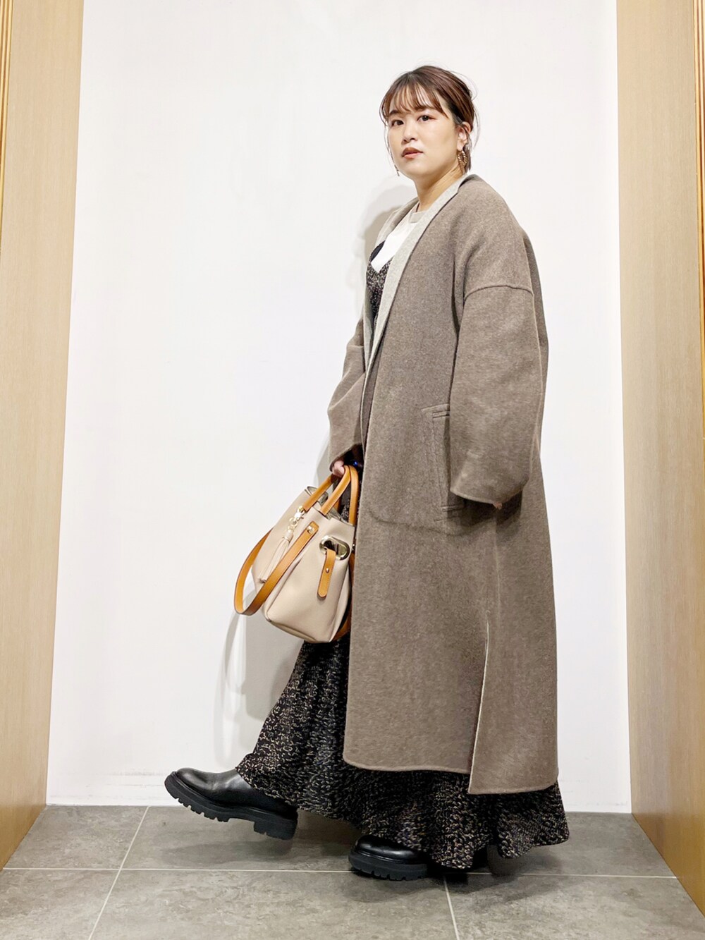 グレー系のその他アウター、ブラック系のワンピース、ベージュ系のトートバッグを着用したレディースの秋コーディネートの4枚目の写真