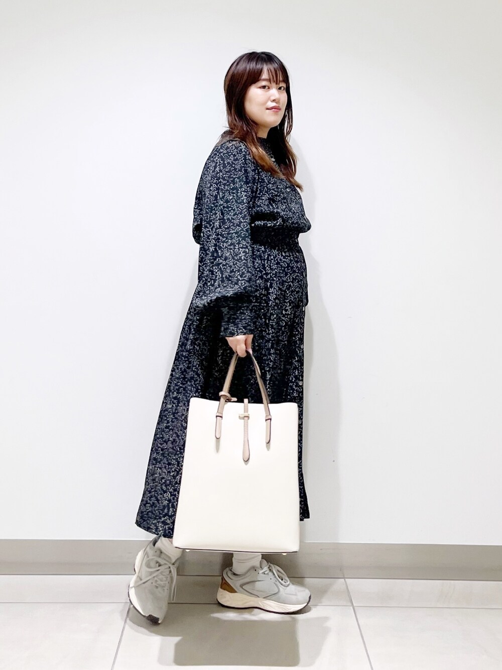 ブラック系のワンピース、ホワイト系のトートバッグ、グレー系のスニーカーを着用したレディースの夏コーディネートの10枚目の写真