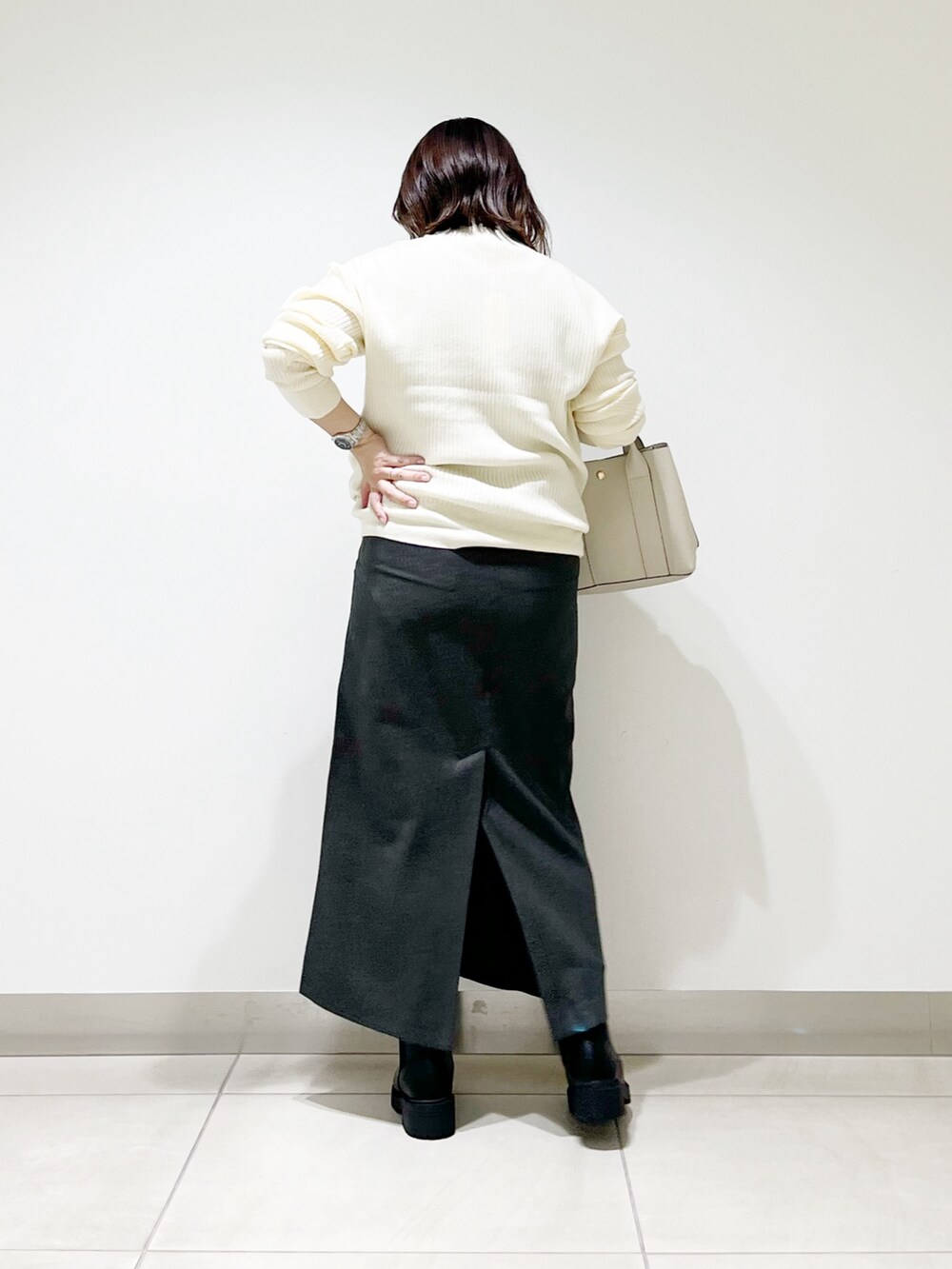 ホワイト系のニット/セーター、ホワイト系のトートバッグ、グレー系のスカートを着用したレディースの秋コーディネートの6枚目の写真