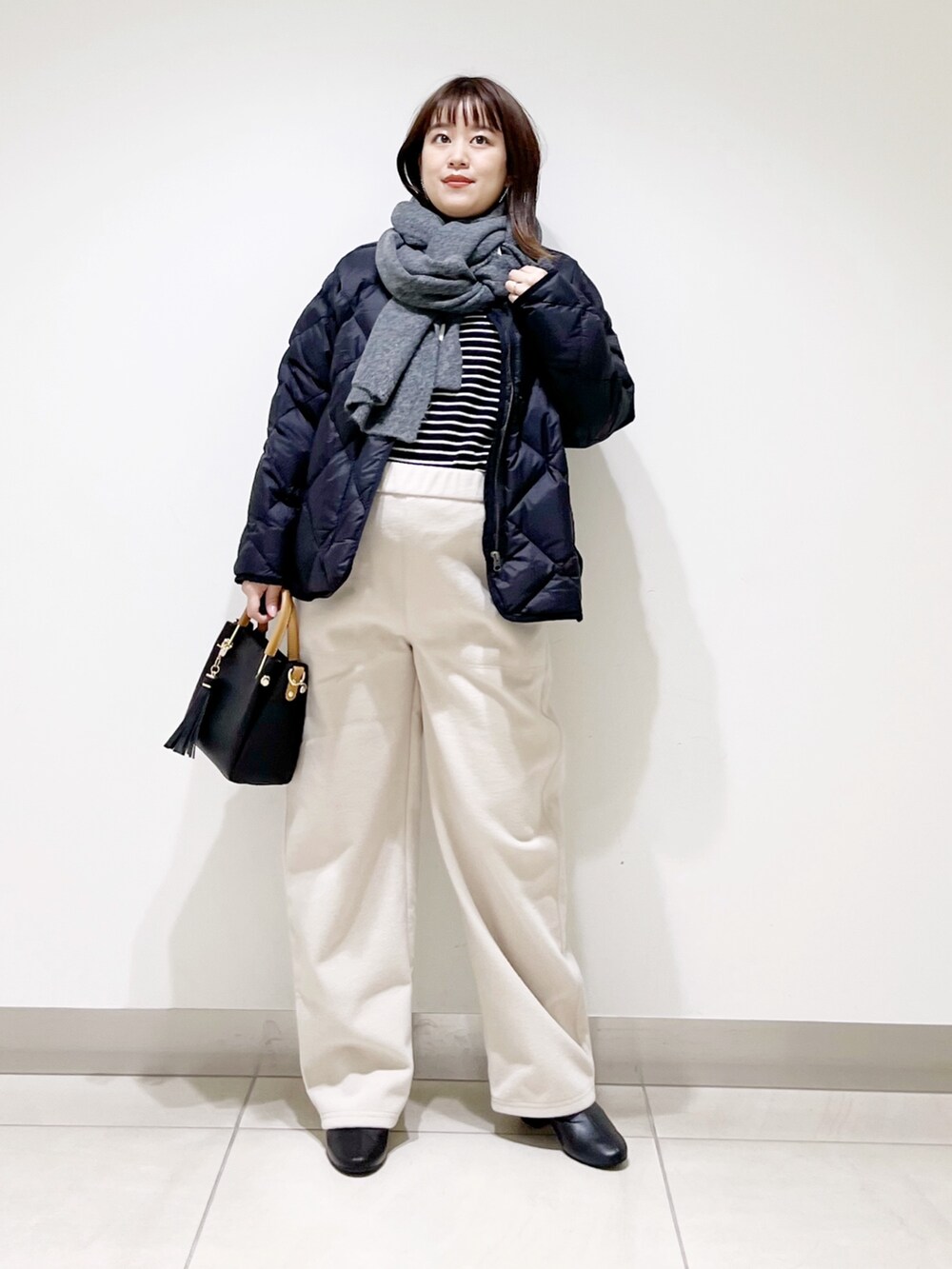 ブラック系のTシャツ/カットソー、ブラック系のダウンジャケット/コート、ブラック系のトートバッグを着用したレディースの秋コーディネートの9枚目の写真