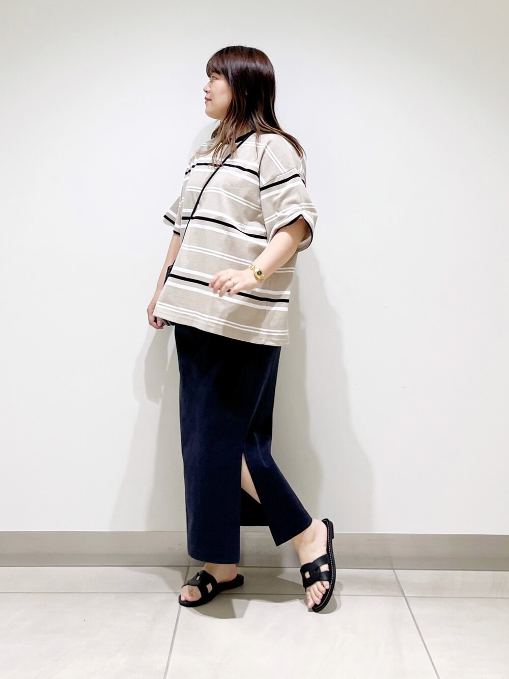 ベージュ系のTシャツ/カットソー、ブルー系のスカート、ブラック系のショルダーバッグを着用したレディースの夏コーディネートの6枚目の写真