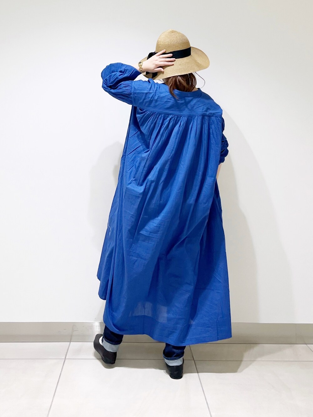 ブルー系のワンピース、ブルー系のデニムパンツ、ブラック系のバレエシューズを着用したレディースの春コーディネートの4枚目の写真