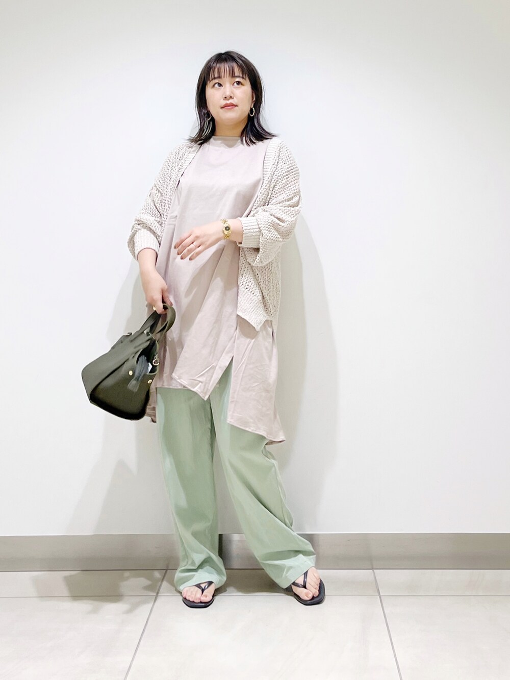 ホワイト系のカーディガン/ボレロ、ベージュ系のTシャツ/カットソー、グリーン系のハンドバッグを着用したレディースの夏コーディネートの2枚目の写真
