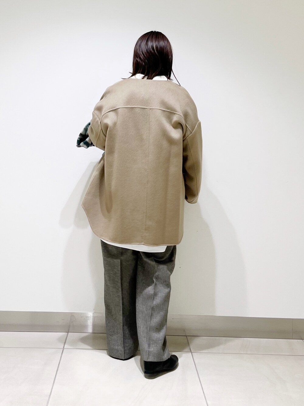 ベージュ系のノーカラージャケット、ホワイト系のニット/セーター、グレー系のその他パンツを着用したレディースの秋コーディネートの6枚目の写真