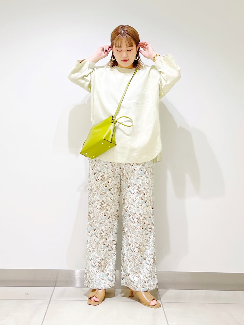 ホワイト系のその他パンツ、グリーン系のショルダーバッグ、ベージュ系のTシャツ/カットソーを着用したレディースの春コーディネートの2枚目の写真