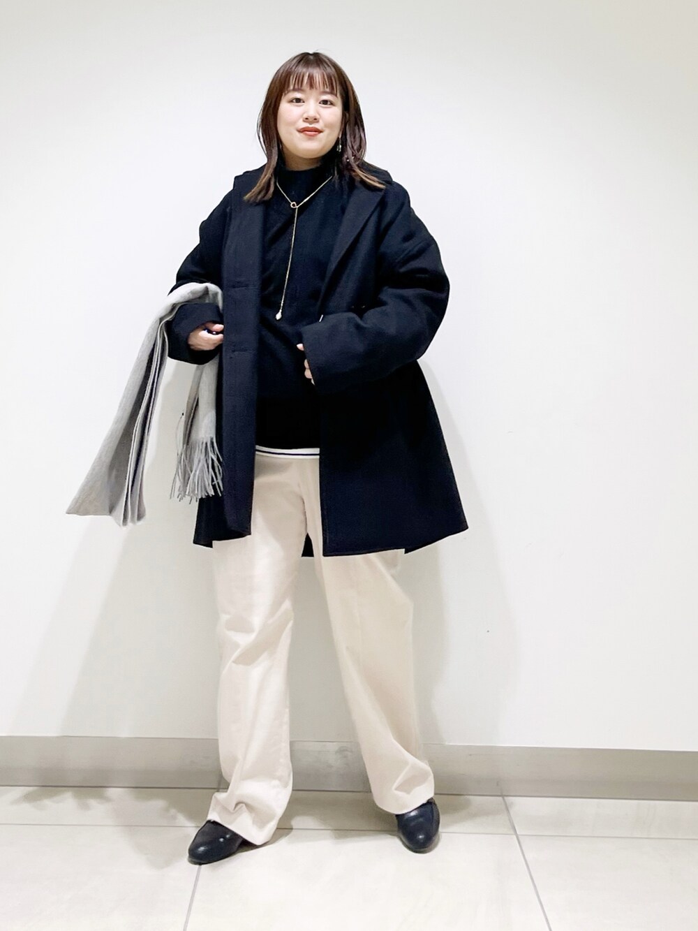ブルー系のピーコート、ブラック系のニット/セーター、ホワイト系のTシャツ/カットソーを着用したレディースの冬コーディネートの9枚目の写真
