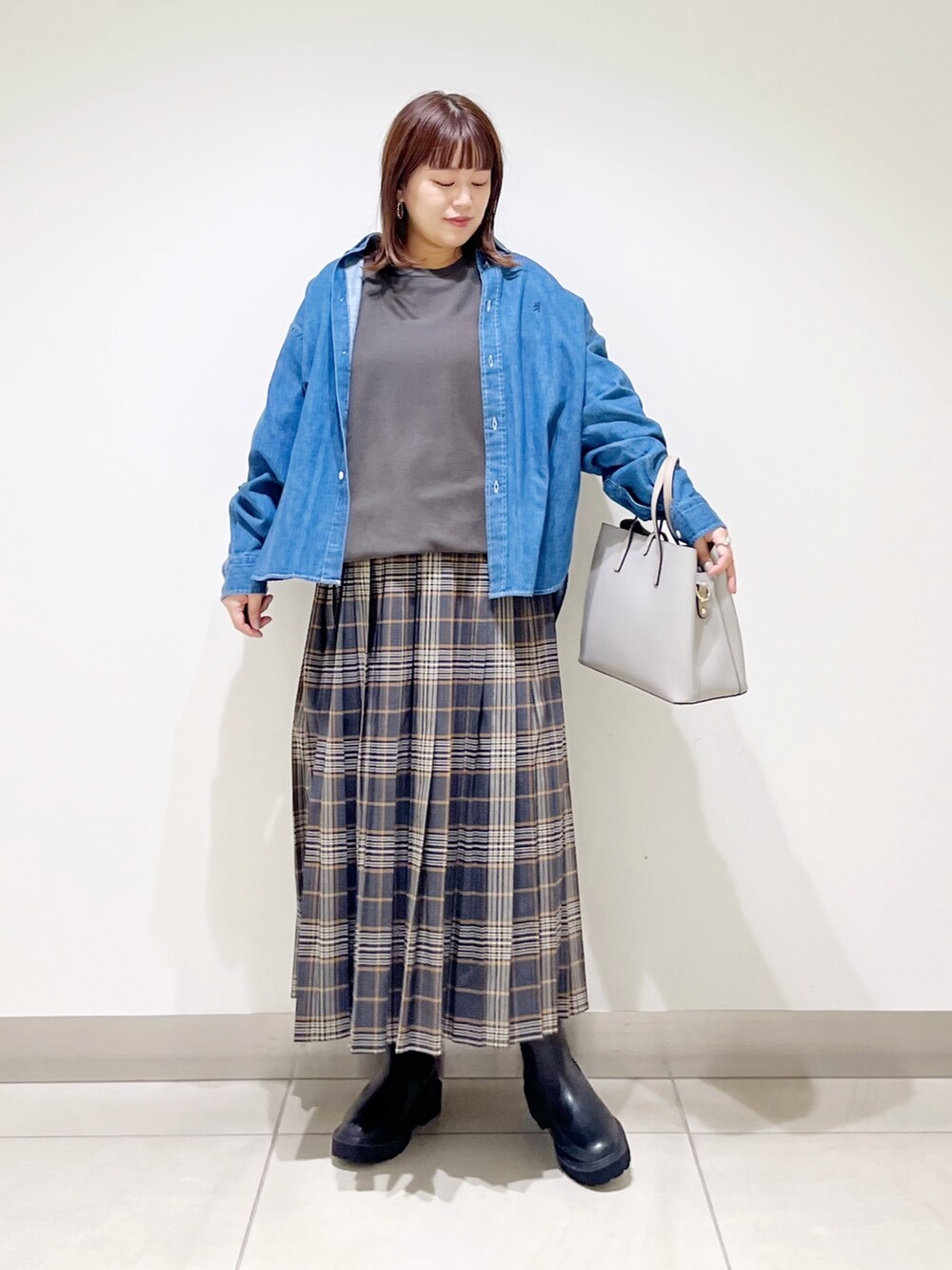 グレー系のTシャツ/カットソー、グレー系のトートバッグ、グレー系のスカートを着用したレディースの秋コーディネートの2枚目の写真