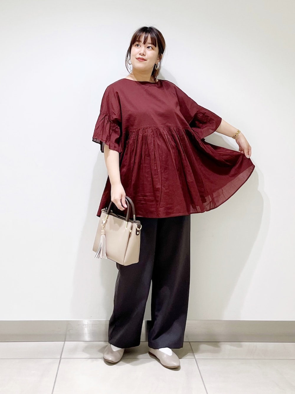 レッド系のシャツ/ブラウス、グレー系のその他パンツ、ベージュ系のトートバッグを着用したレディースの夏コーディネートの2枚目の写真