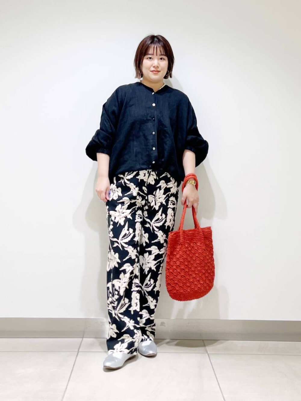 シルバー系のパンプス、ブラック系のその他パンツ、オレンジ系のトートバッグを着用したレディースの春コーディネートの4枚目の写真