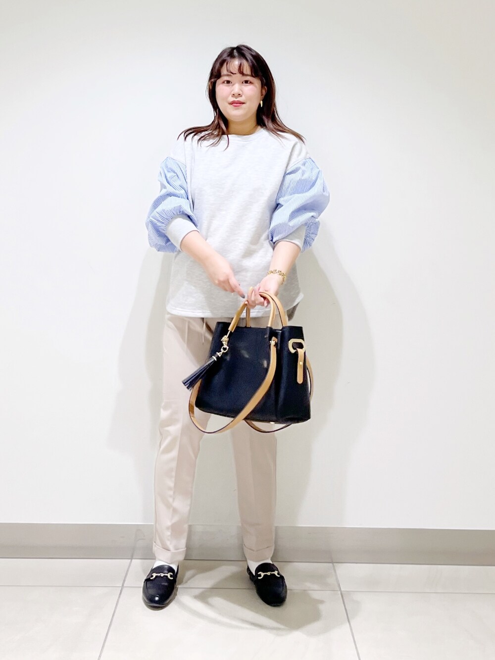 グレー系のTシャツ/カットソー、ベージュ系のその他パンツ、ブラック系のトートバッグを着用したレディースの春コーディネートの5枚目の写真