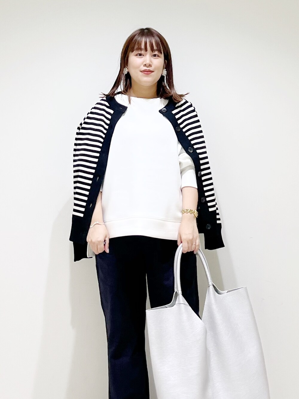 ホワイト系のTシャツ/カットソー、ブラック系のカーディガン/ボレロ、ブルー系のその他パンツを着用したレディースの秋コーディネートの2枚目の写真