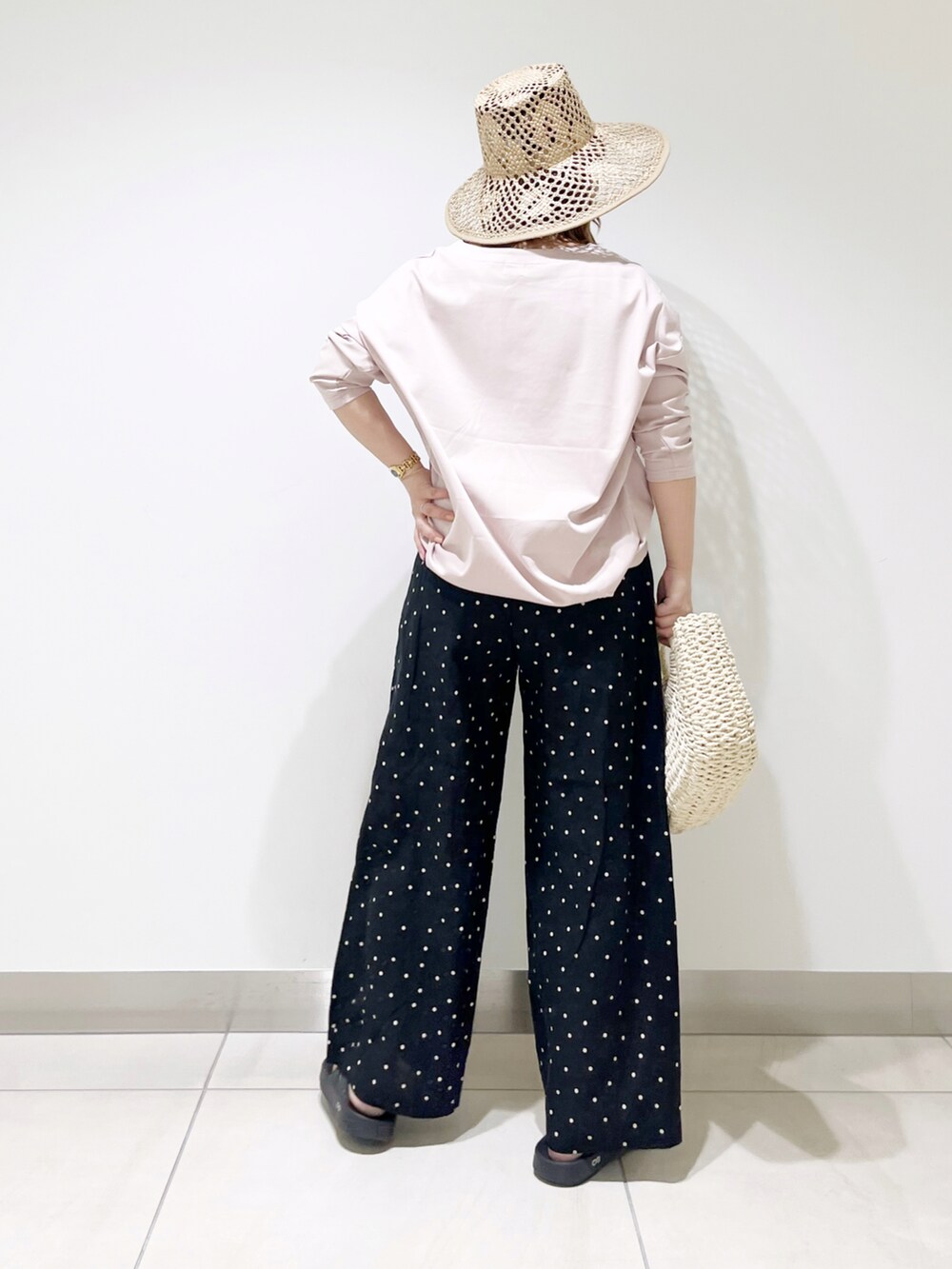 ブラック系のその他パンツ、ピンク系のTシャツ/カットソー、ホワイト系のハンドバッグを着用したレディースの春コーディネートの3枚目の写真