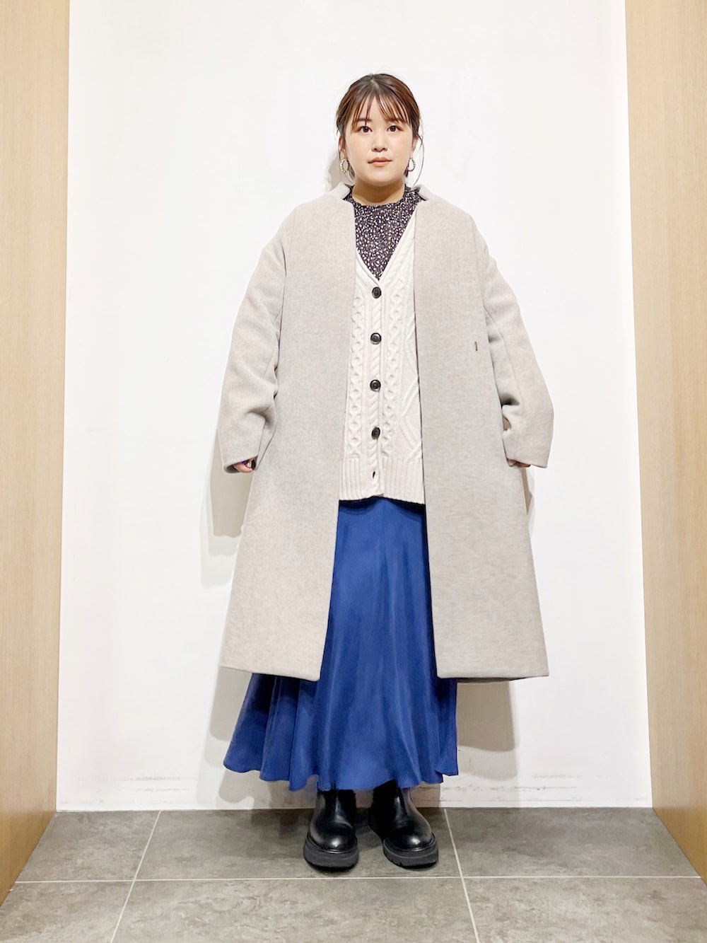 グレー系のその他アウター、ブルー系のスカート、ブラック系のブーツを着用したレディースの冬コーディネートの4枚目の写真