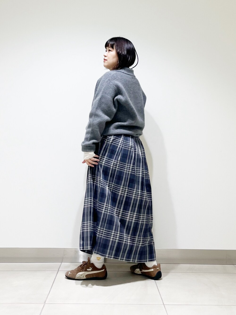 グレー系のニット/セーター、ホワイト系のTシャツ/カットソー、ホワイト系のバッグを着用したレディースの秋コーディネートの5枚目の写真