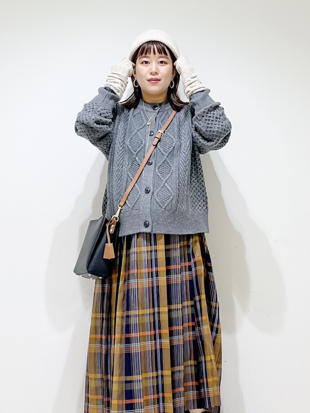 グレー系のカーディガン/ボレロ、ブルー系のスカート、ブラック系のショルダーバッグを着用したレディースの冬コーディネートの7枚目の写真