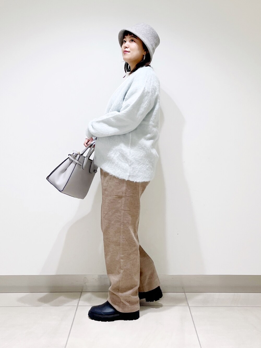 グリーン系のカーディガン/ボレロ、ベージュ系のその他パンツ、ブラック系のブーツを着用したレディースの秋コーディネートの4枚目の写真