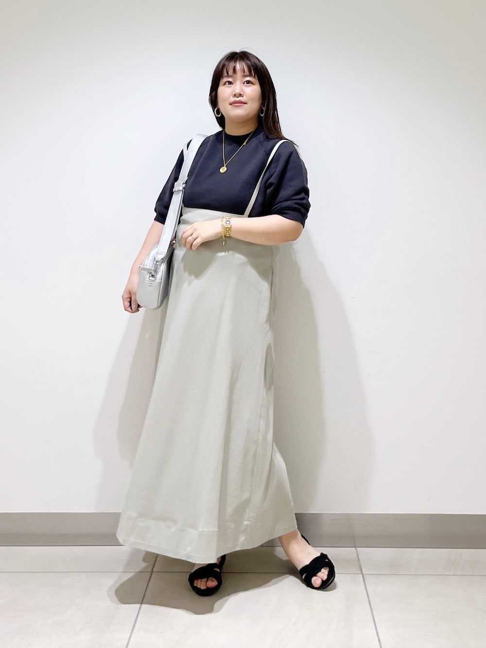 グレー系のTシャツ/カットソー、ベージュ系のスカート、シルバー系のショルダーバッグを着用したレディースの春コーディネートの2枚目の写真