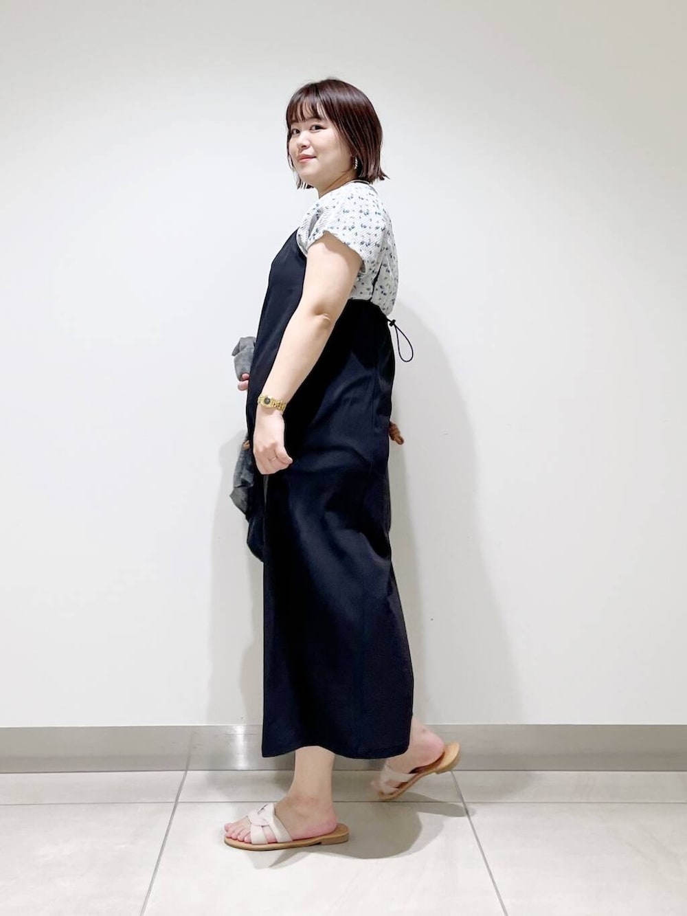 ブラック系のトートバッグ、グレー系のカーディガン/ボレロ、ホワイト系のサンダルを着用したレディースの春コーディネートの5枚目の写真