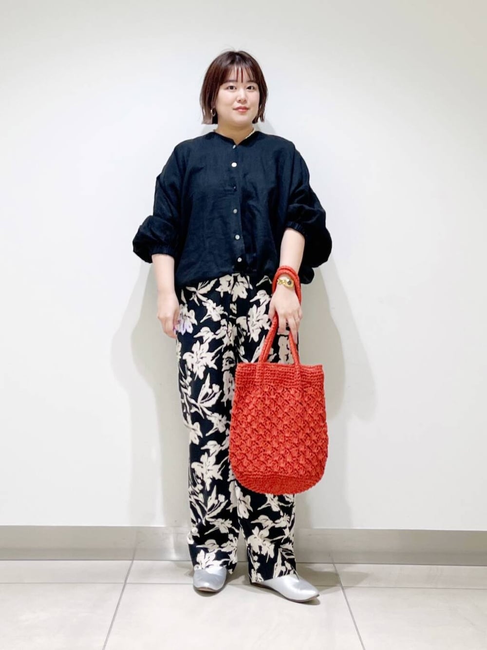 シルバー系のパンプス、ブラック系のその他パンツ、オレンジ系のトートバッグを着用したレディースの春コーディネートの2枚目の写真