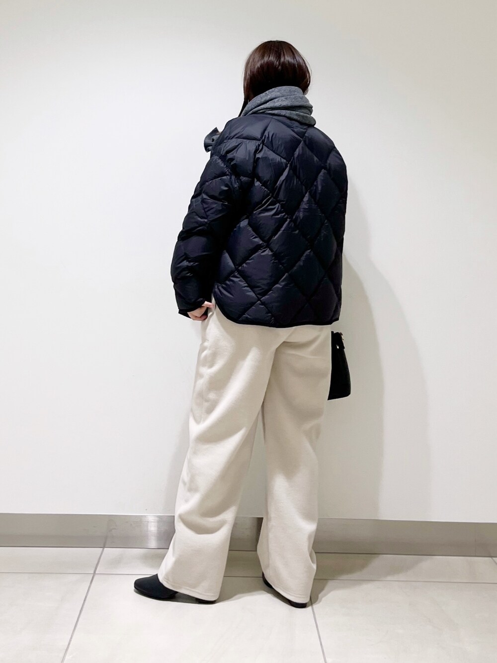 ブラック系のTシャツ/カットソー、ブラック系のダウンジャケット/コート、ブラック系のトートバッグを着用したレディースの秋コーディネートの7枚目の写真