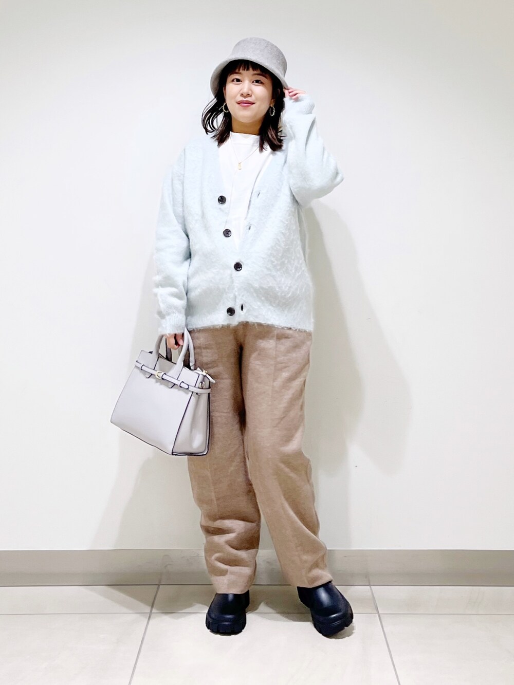 グリーン系のカーディガン/ボレロ、ベージュ系のその他パンツ、ブラック系のブーツを着用したレディースの秋コーディネートの7枚目の写真