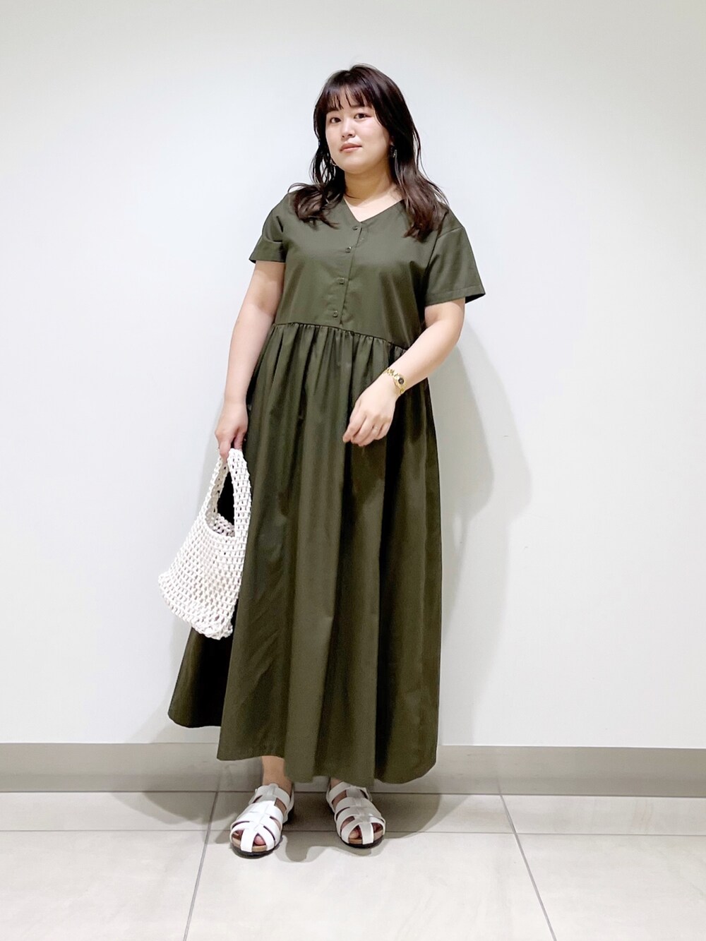 グリーン系のワンピース、ホワイト系のバッグ、ホワイト系のシューズを着用したレディースの春コーディネートの5枚目の写真