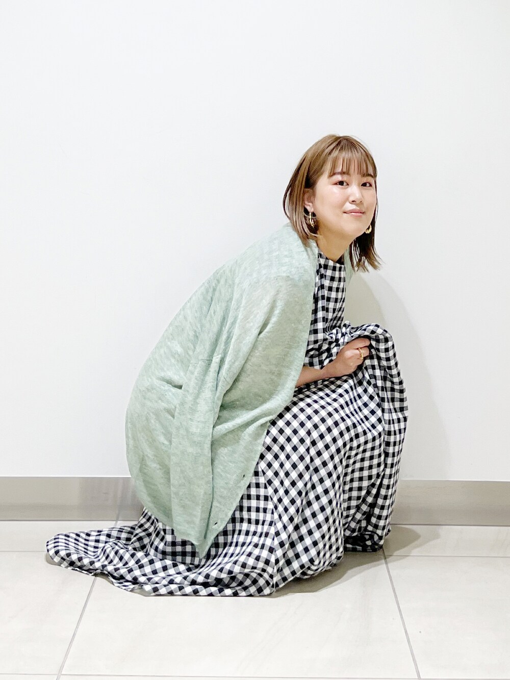 その他のワンピース、ホワイト系のサンダル、グリーン系のカーディガン/ボレロを着用したレディースの春コーディネートの2枚目の写真