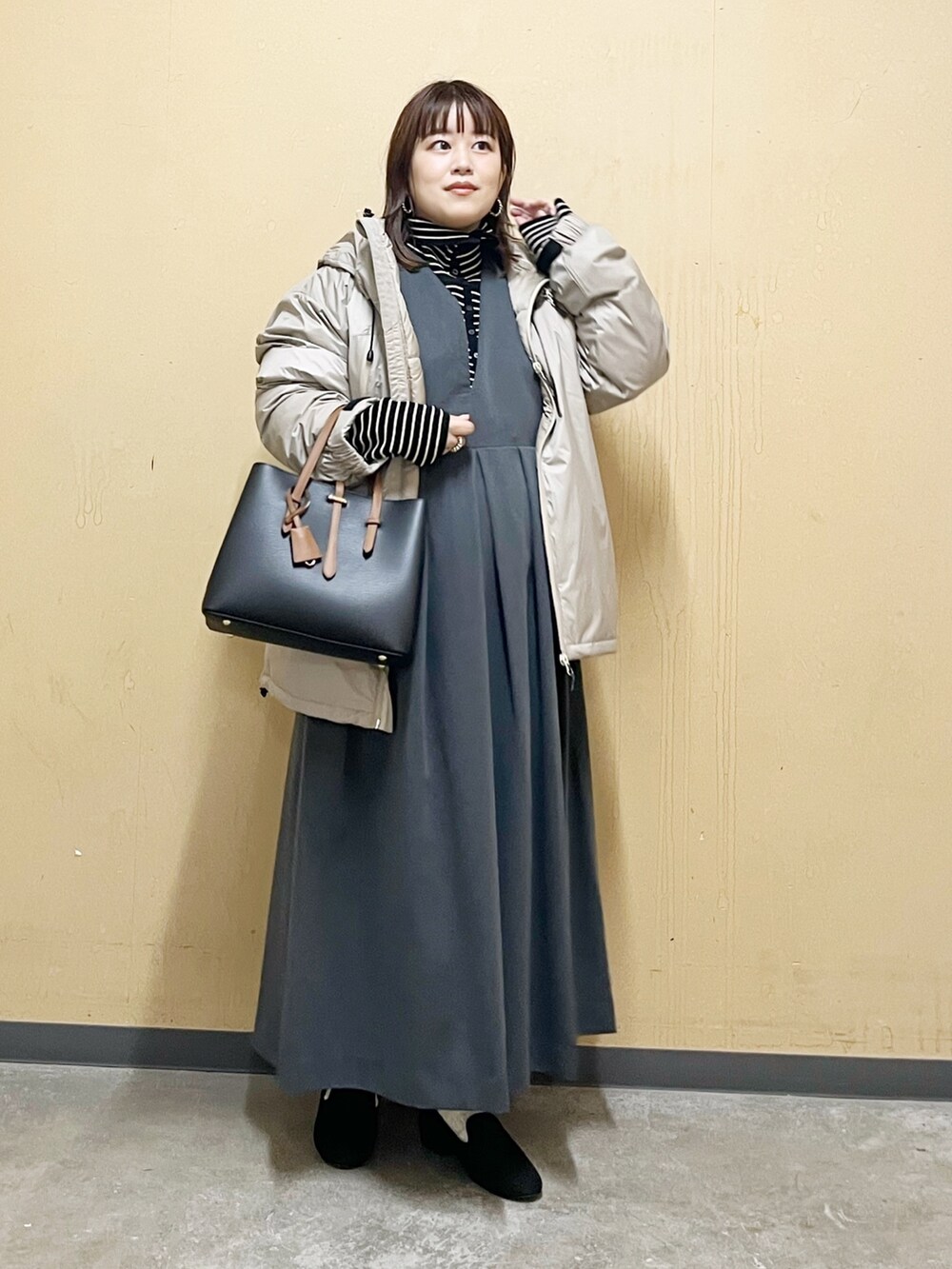 ベージュ系のダウンジャケット/コート、ブラック系のニット/セーター、グレー系のワンピース/ドレスを着用したレディースの秋コーディネートの10枚目の写真