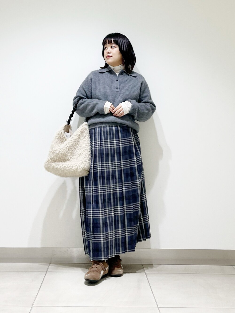 グレー系のニット/セーター、ホワイト系のTシャツ/カットソー、ホワイト系のバッグを着用したレディースの秋コーディネートの3枚目の写真