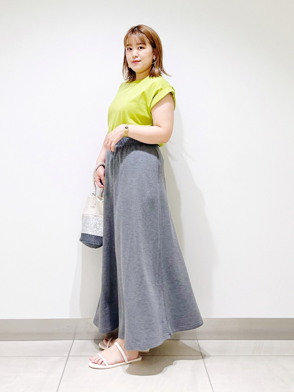 グリーン系のTシャツ/カットソー、グレー系のスカート、その他のハンドバッグを着用したレディースの夏コーディネートの3枚目の写真