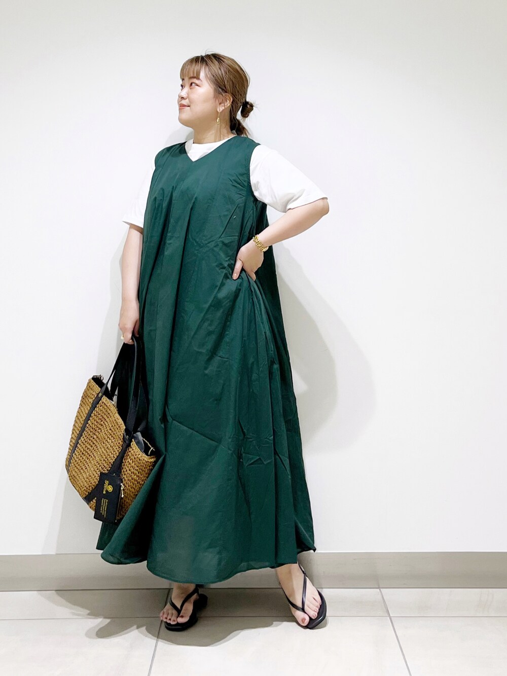 グリーン系のワンピース、イエロー系のトートバッグ、ブラック系のサンダルを着用したレディースの夏コーディネートの2枚目の写真