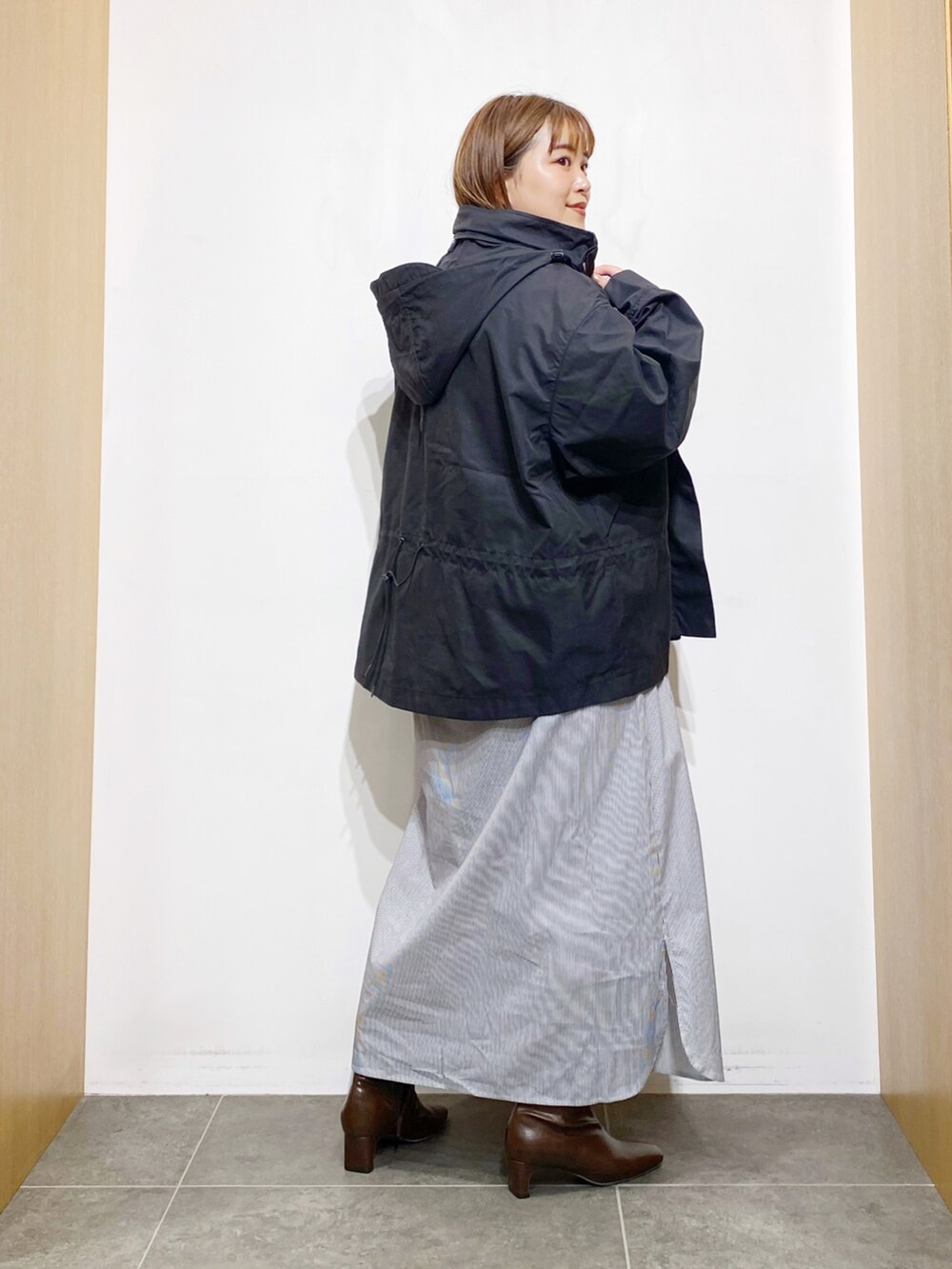 ブラック系のその他アウター、ホワイト系のワンピース、ブラウン系のブーツを着用したレディースの秋コーディネートの3枚目の写真