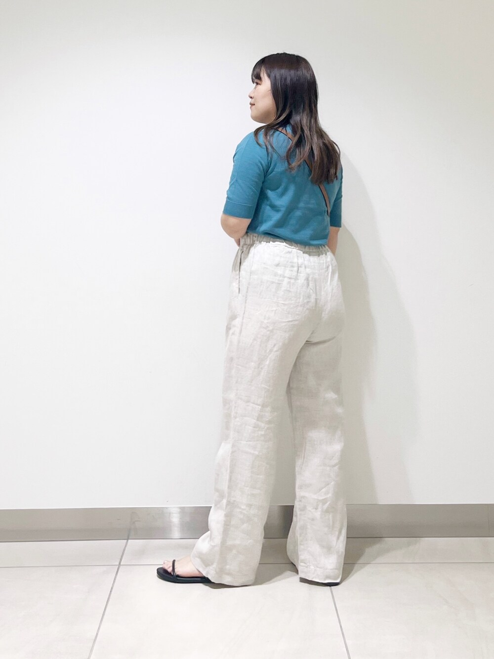 ブルー系のニット/セーター、ベージュ系のその他パンツ、ブラック系のショルダーバッグを着用したレディースの春コーディネートの7枚目の写真