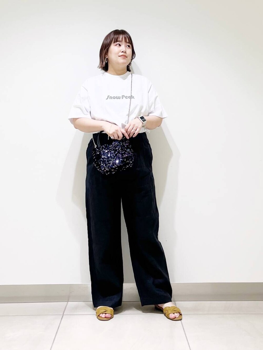 ブラック系のショルダーバッグ、ブラック系のその他パンツ、イエロー系のサンダルを着用したレディースの春コーディネートの2枚目の写真