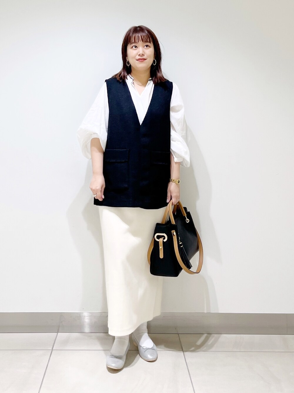 ブラック系のトップス、ホワイト系のシャツ/ブラウス、その他のスカートを着用したレディースの秋コーディネートの8枚目の写真