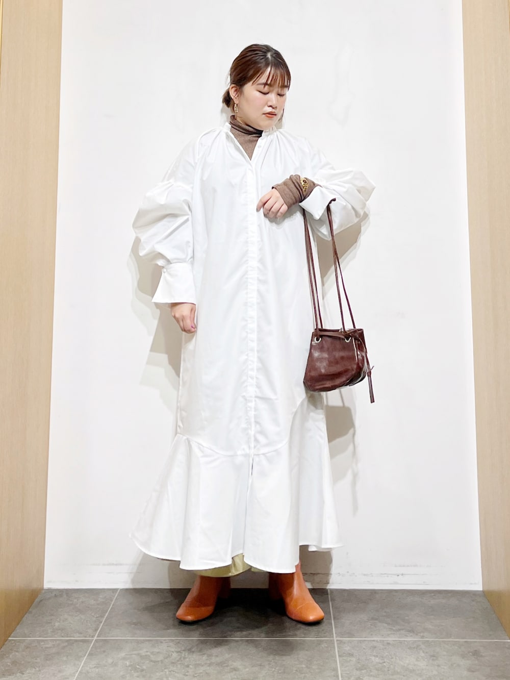 ホワイト系のワンピース、ブラウン系のハンドバッグ、ブラウン系のTシャツ/カットソーを着用したレディースの秋コーディネートの3枚目の写真