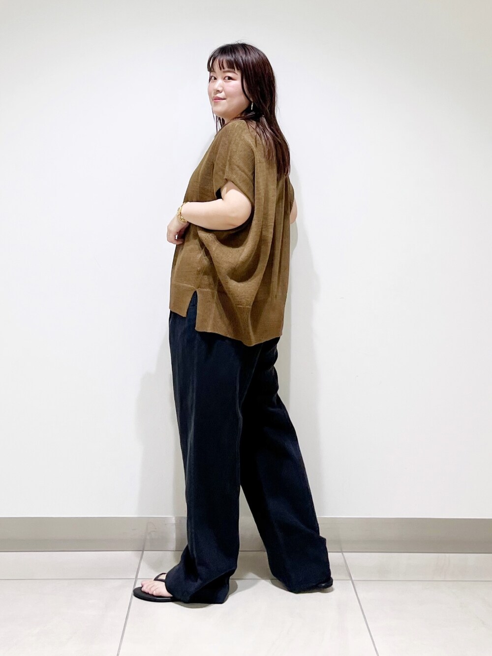 イエロー系のトップス、ブラック系のその他パンツ、ブラック系のサンダルを着用したレディースの夏コーディネートの3枚目の写真