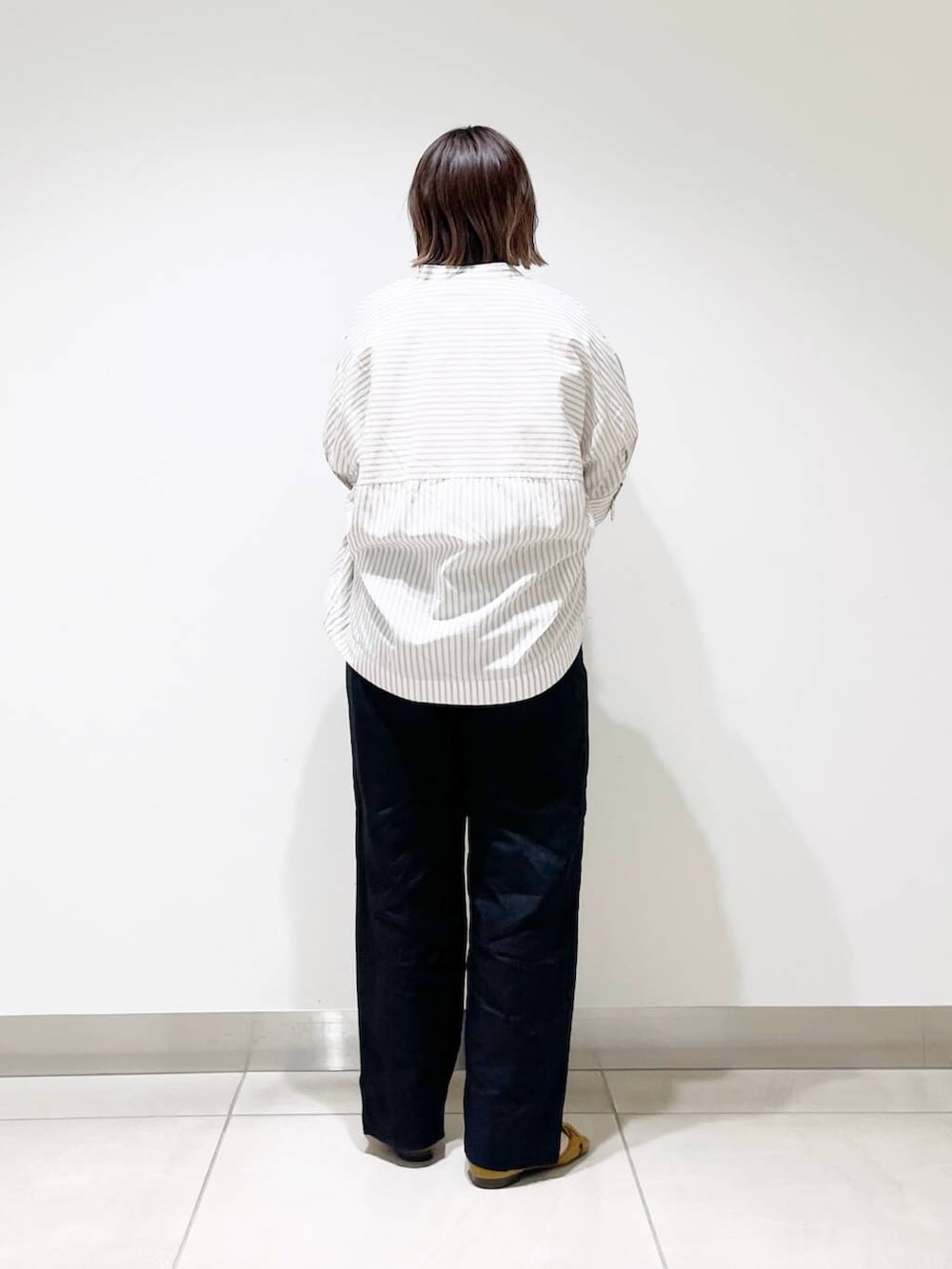 ブラック系のその他パンツ、ベージュ系のシャツ/ブラウス、イエロー系のサンダルを着用したレディースの春コーディネートの4枚目の写真