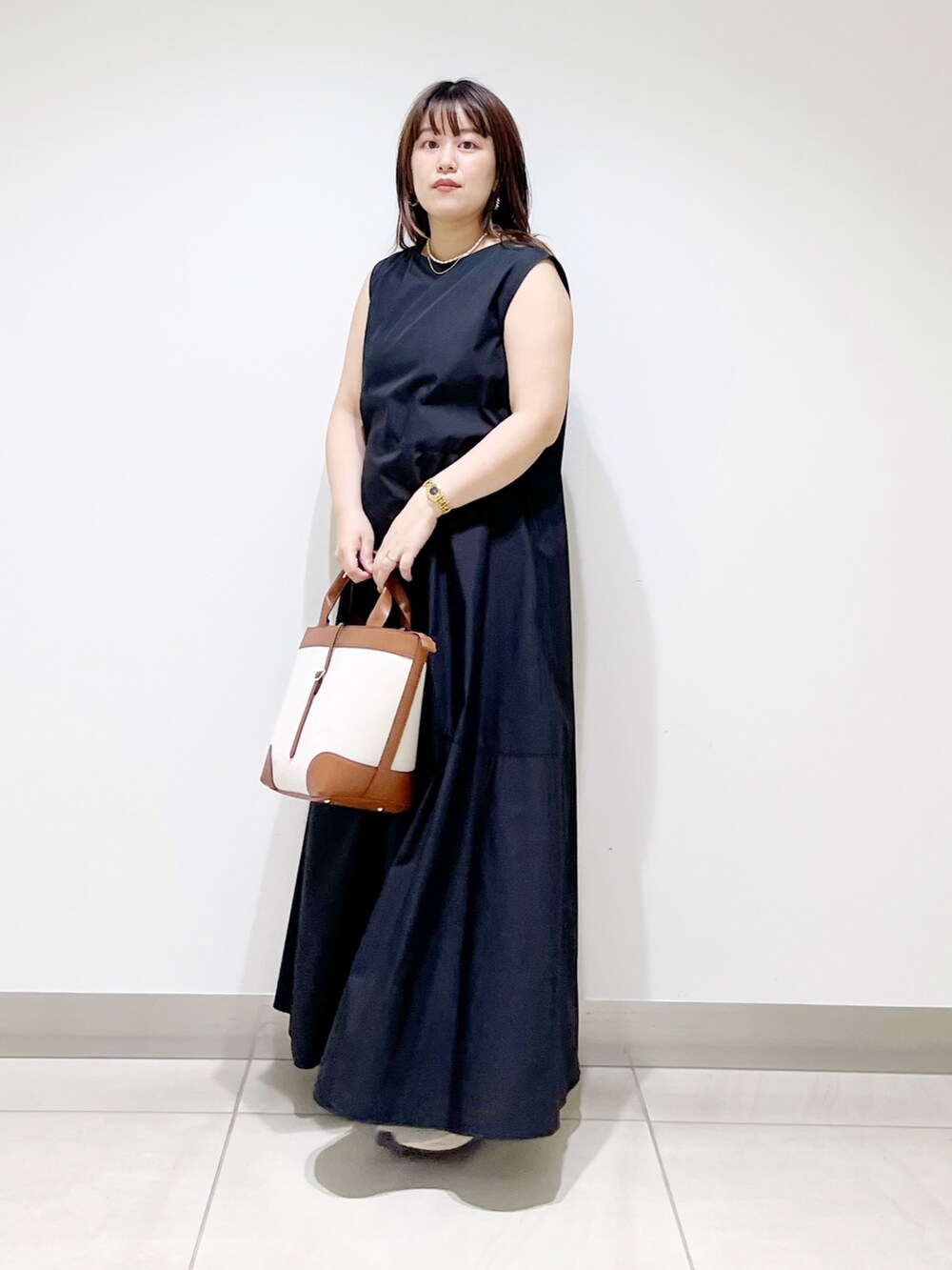 ブラック系のワンピース/ドレス、イエロー系のトートバッグ、グレー系のスニーカーを着用したレディースの夏コーディネートの4枚目の写真