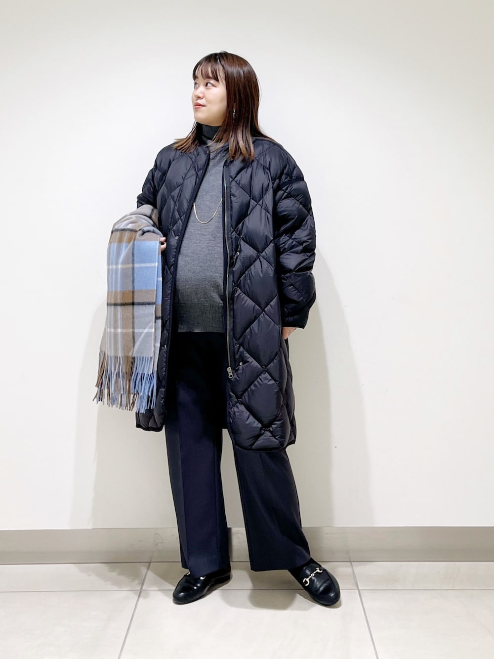 ブラック系のダウンジャケット/コート、グレー系のニット/セーター、グレー系のその他パンツを着用したレディースの冬コーディネートの2枚目の写真