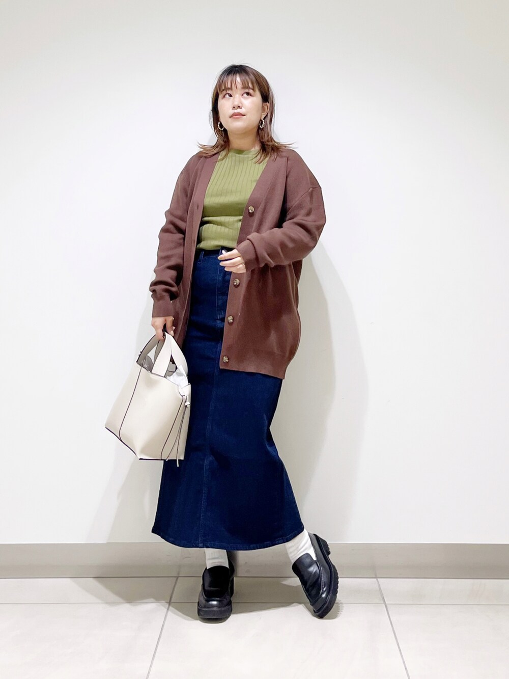 ブラウン系のカーディガン/ボレロ、グリーン系のTシャツ/カットソー、ホワイト系のトートバッグを着用したレディースの秋コーディネートの3枚目の写真