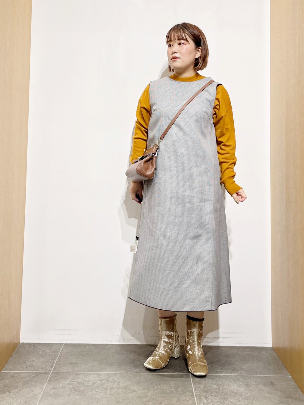 ブラック系のワンピース、ベージュ系のブーツ、ブラウン系のショルダーバッグを着用したレディースの秋コーディネートの4枚目の写真