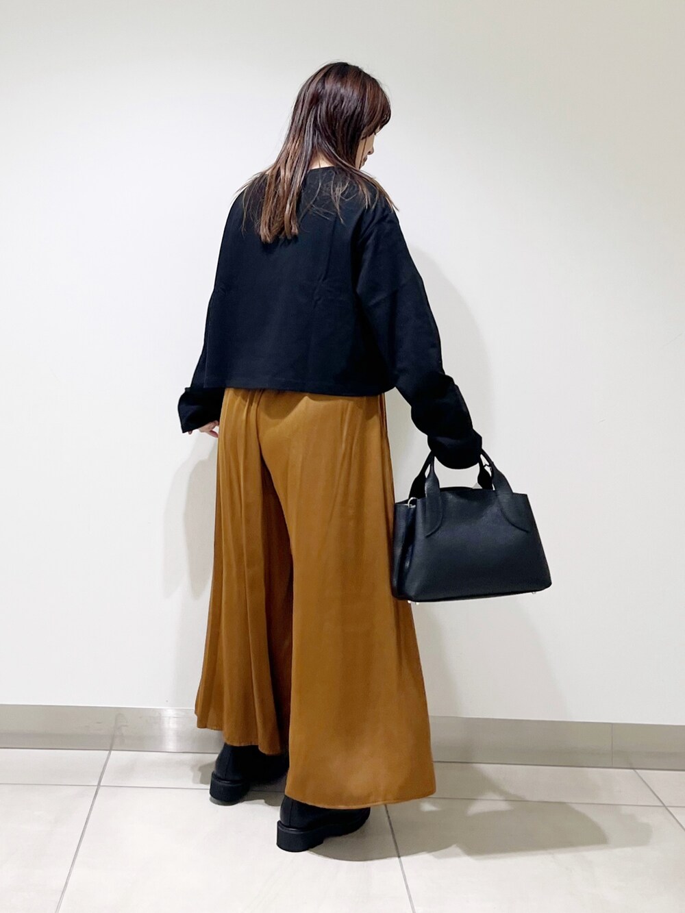 ブラック系のTシャツ/カットソー、イエロー系のパンツ、ブラック系のハンドバッグを着用したレディースの夏コーディネートの5枚目の写真