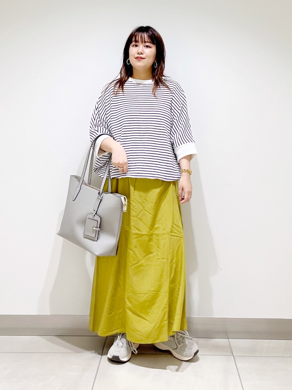 その他のスカート、グレー系のスニーカー、グレー系のトートバッグを着用したレディースの夏コーディネートの3枚目の写真